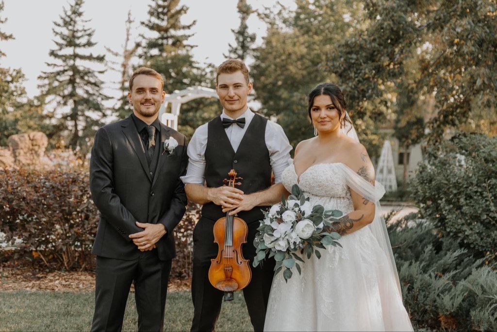 Allan Palmer performing at a wedding with the bride and groom